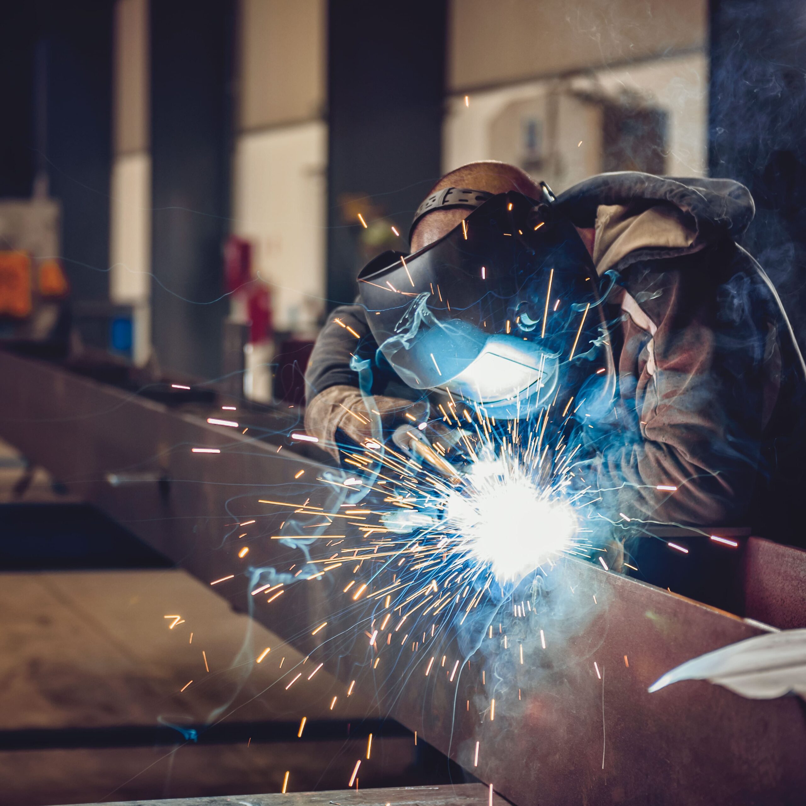 Industrial Welder With Torch and Protective Helmet